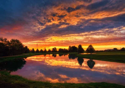 Golden sunlight bathes the lush green landscape of Harbour View Golf & Country Club in Gilford, Innisfil, near CozyCotts, as dusk approaches. The serene setting offers a picturesque backdrop for golfers, inviting them to savor a round amidst the tranquil beauty of the course.