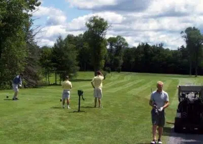 Harbour View Golf At Golfers enjoying a game amidst the vibrant green expanse of Harbour View Golf & Country Club in Gilford, Innisfil, located near CozyCotts. The lush grass creates a picturesque setting, inviting players to experience a tranquil round surrounded by the serene beauty of the course.Innisfil