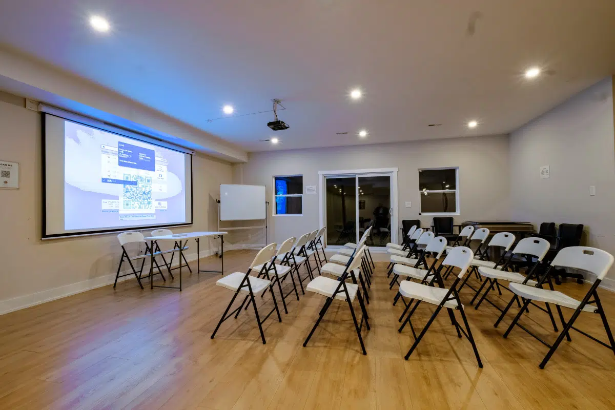 Projector and large screen setup in the Green River villa at CozyCotts Stay, ideal for group presentations, seminars, and movie nights.