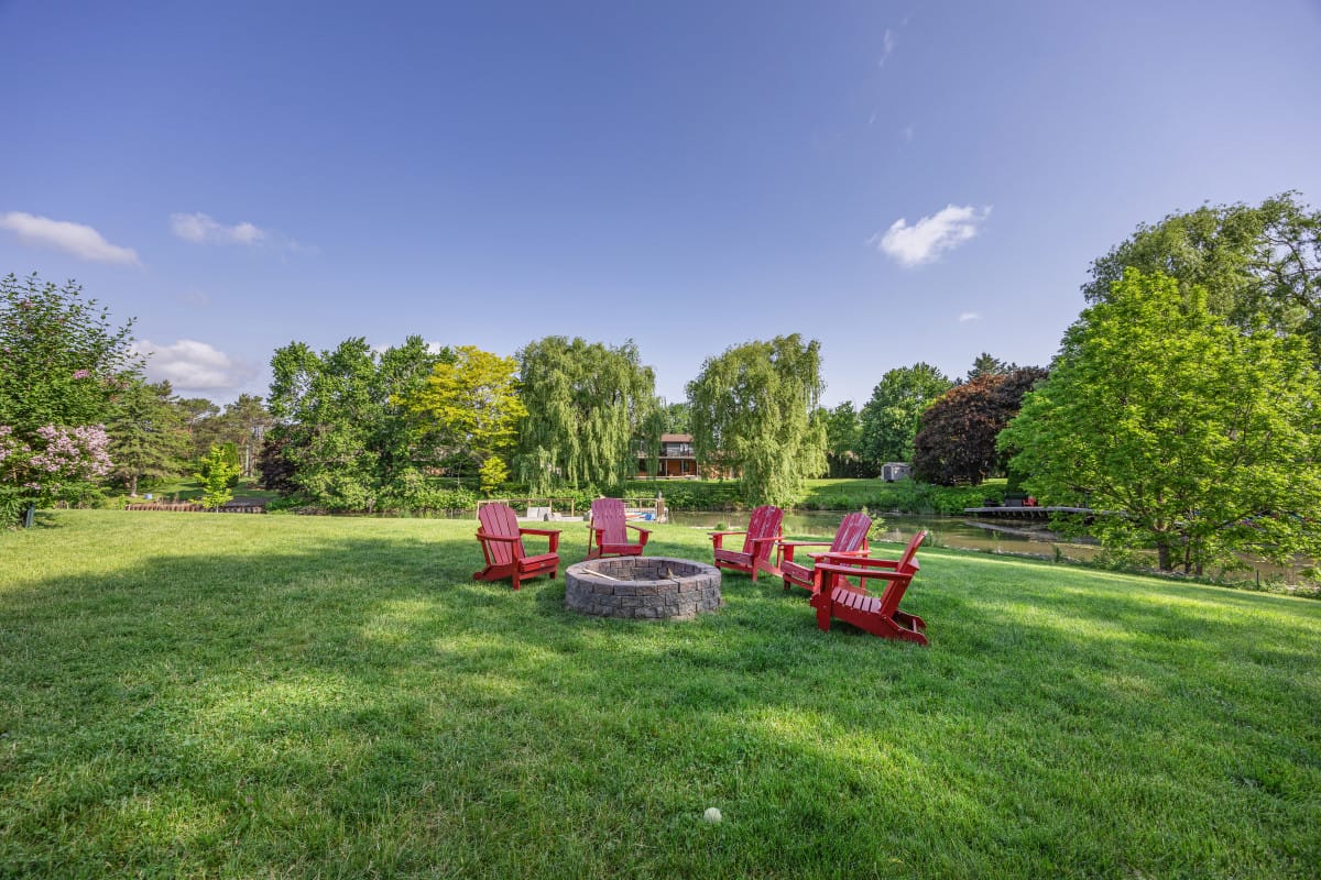 Recreational room with pool table, dartboard, wooden floor, projector screen, and office chair.