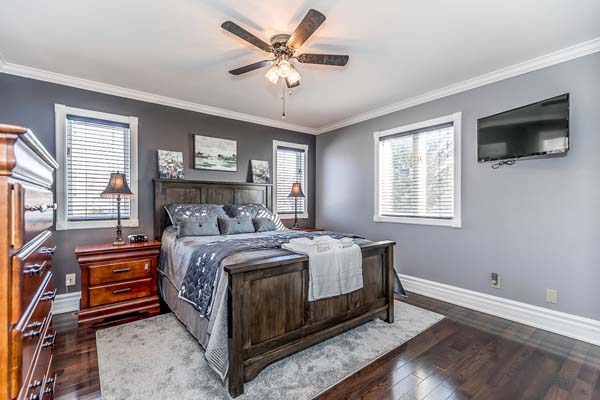 Recreational room with pool table, dartboard, wooden floor, projector screen, and office chair.